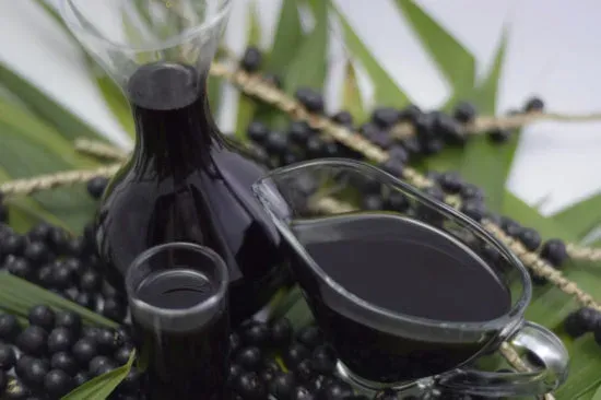 Óleo de açaí em frasco e em pote, com cachos de açaí ao redor
