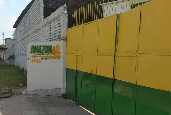 Fachada da fábrica da Amazon Oil em Ananindeua, com a placa da empresa no muro amarelo e verde